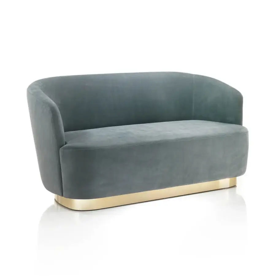 Coco sofa, dusty teal velvet, rounded cocoon shape with brass base and curved armrests, studio product shot.