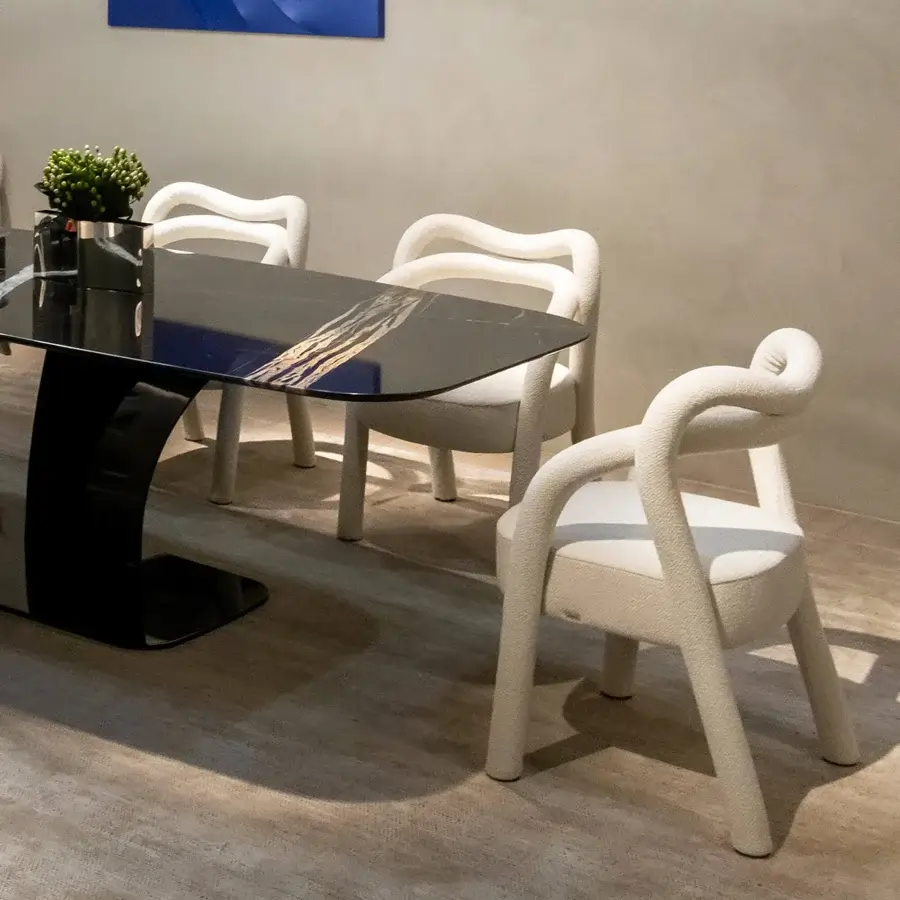 Sophisticated Rugiano Abbraccio armchair with enveloping form upholstered in textured off-white fabric and bronzed brass details exhibiting a matte finish