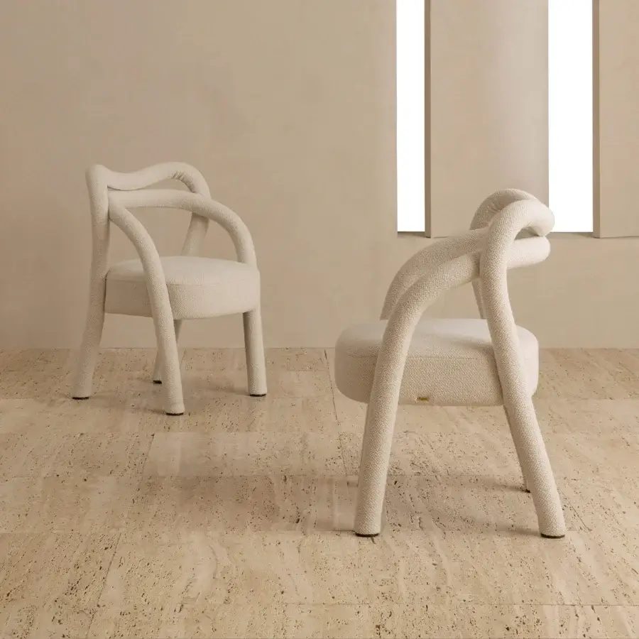 Lavish Rugiano Abbraccio armchair with enveloping form upholstered in textured creamy boucle fabric and bronzed brass details