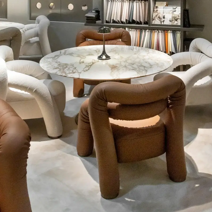Superior Rugiano Abbraccio lounge chair upholstered in brown fabric with bronzed brass details on its fully upholstered base