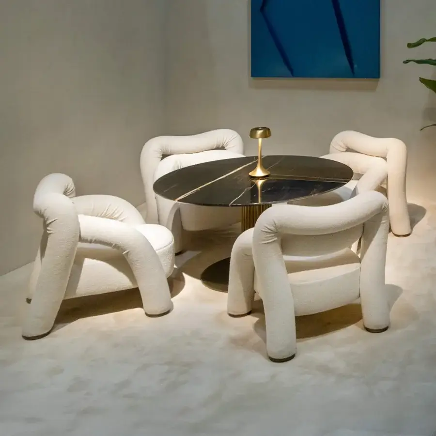 Lavish Rugiano Abbraccio lounge chair upholstered in cream fabric with elegant bronzed brass details