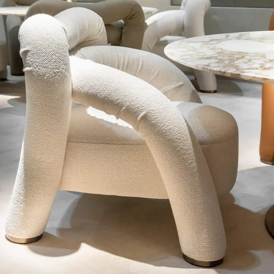 Exceptional Rugiano Abbraccio lounge chair upholstered in textured light beige bouclé fabric with bronzed brass details