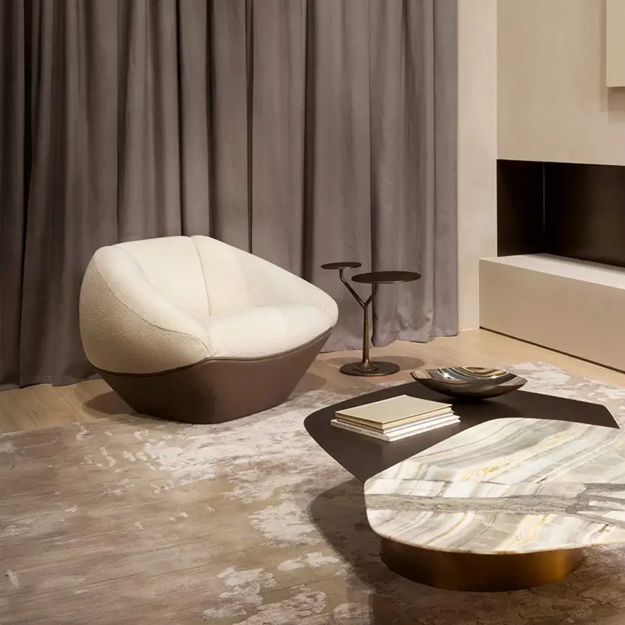 Captivating Rugiano Iside lounge chair with uniquely faceted form and textured cream fabric upholstery, built with lustrous leather base