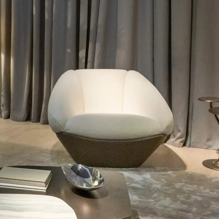 Distinguished Rugiano Iside lounge chair with uniquely faceted silhouette upholstered in creamy fabric and dark leather finish