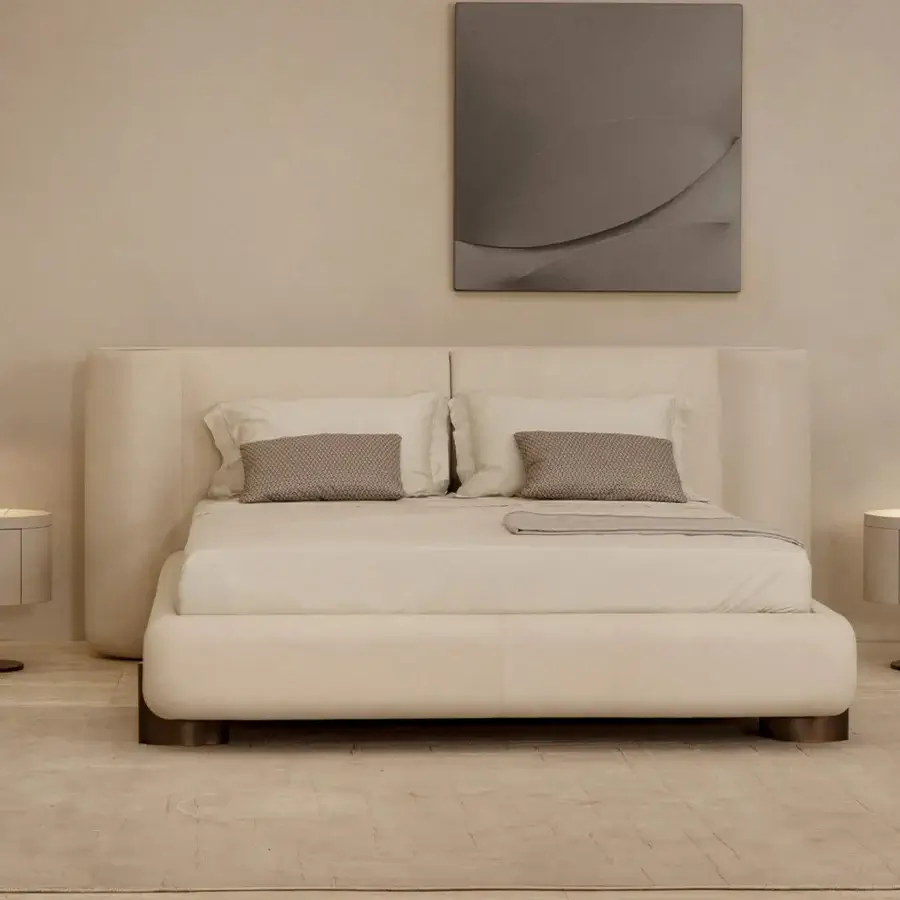 Refined Rugiano Anais bed with a rounded headboard and plush light beige fabric upholstery with bronzed brass details and dark wood base