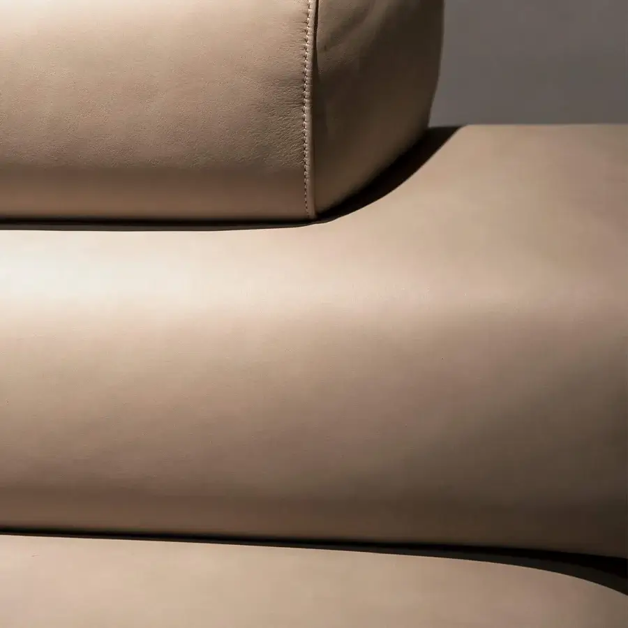 Superior Rugiano Bali sectional with plush cylindrical cushions and subtle bronzed brass details in neutral beige fabric or leather