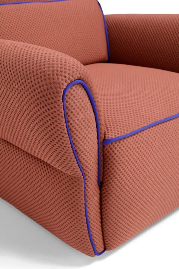 Lavish Egoitaliano Mariù lounge chair built with terracotta two-way stretch fabric and vibrant royal blue piping