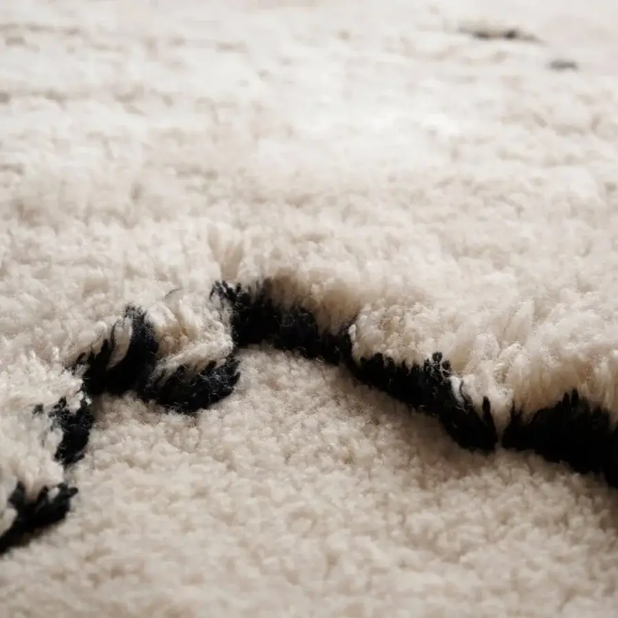 Exceptional Amini Tapiorso rug hand-knotted in India with ivory wool displaying a bold black zigzag pattern and clipped carving