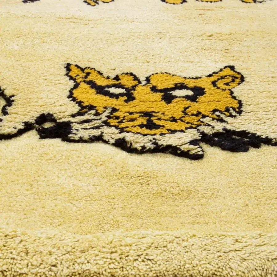 Lavish Amini Tapileo rug hand-knotted in Italy with a golden yellow feline illustration against a pale yellow pure wool pile