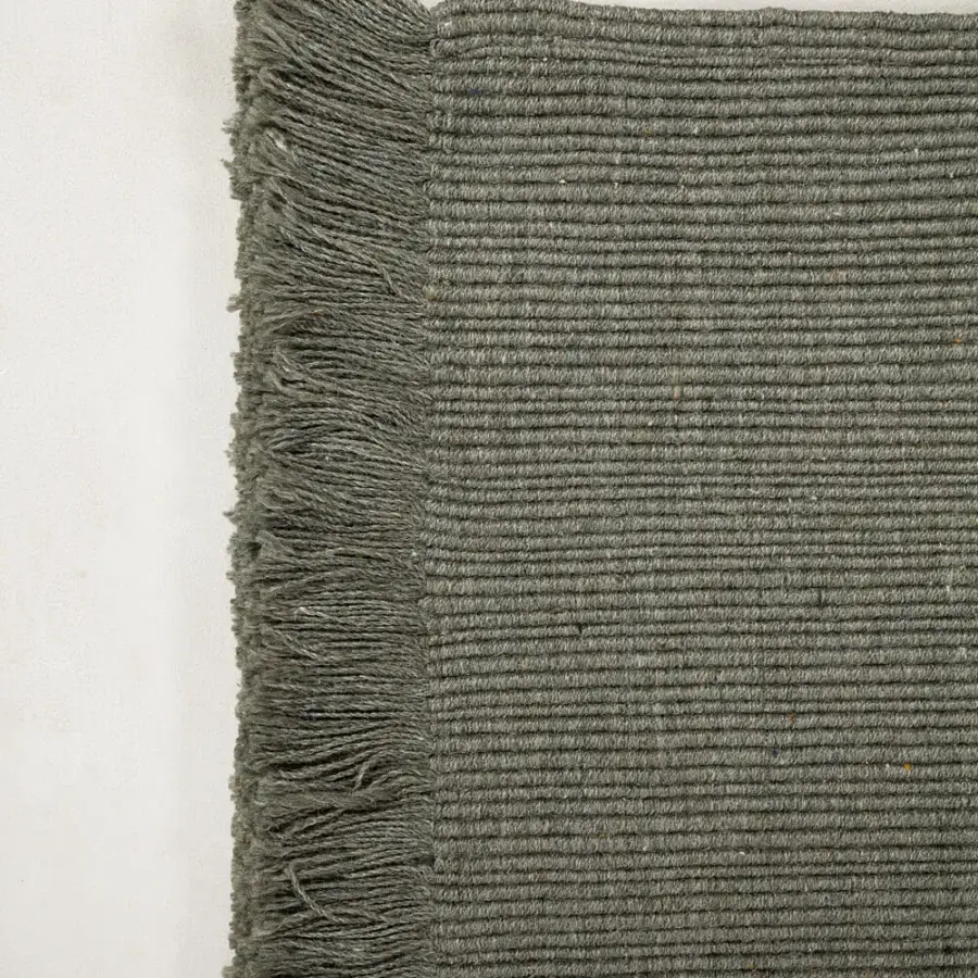 Exceptional Amini Pierre rug hand-woven from recycled PET in muted olive green with delicate fringe detailing