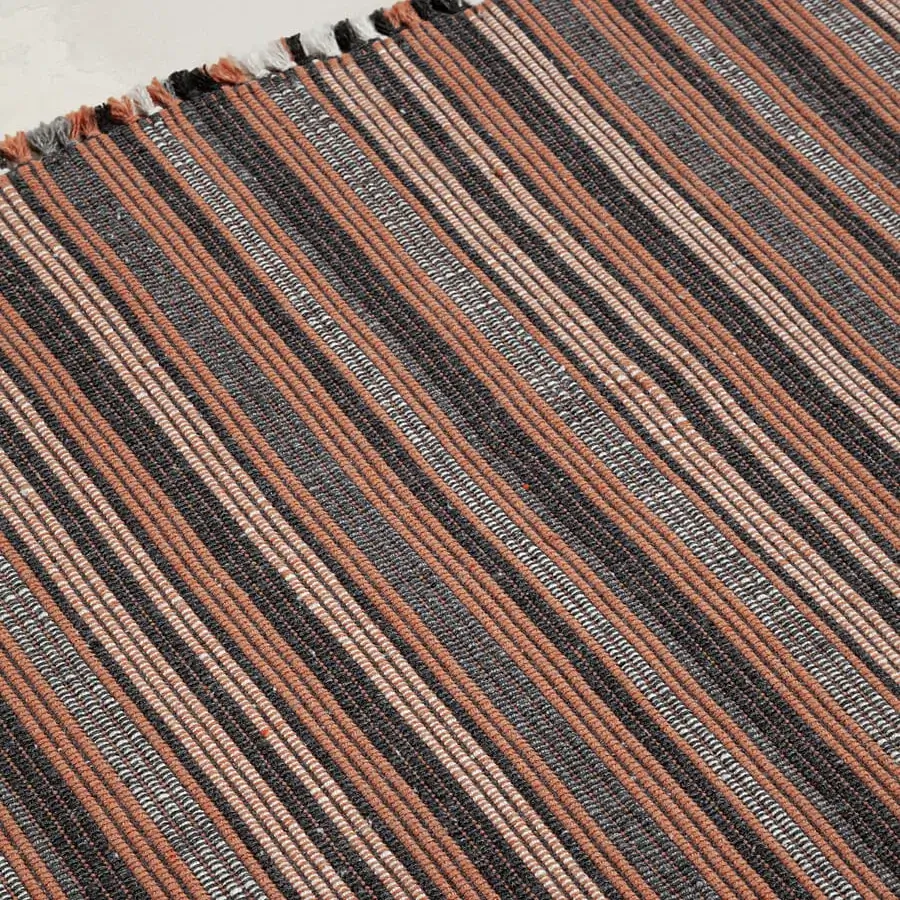 Exceptional Amini Prune rug hand-woven from recycled PET with charcoal and coral striped pattern and hand-clipped edges