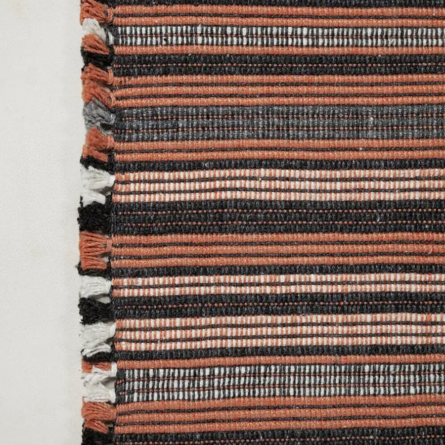 Luxury Amini Prune rug woven from recycled PET with charcoal and coral stripes and a hand-clipped finish