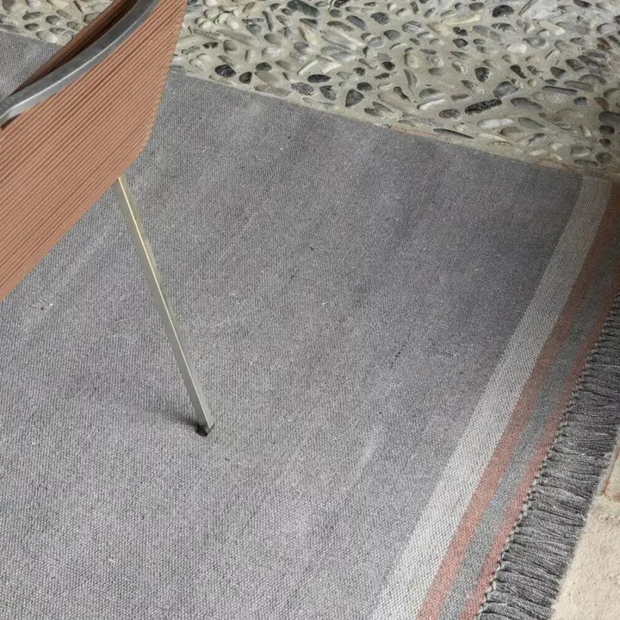 Distinguished Amini Coco rug with grey and off-white stripes crafted from 100% recycled PET with a textured fringe and hand-clipped finish