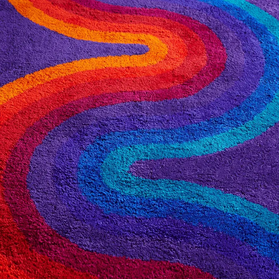 Superior Amini Romantica-Curve rug showcasing chromatic bands in purple, red, orange, yellow, and blue New Zealand wool with hand-washed carving