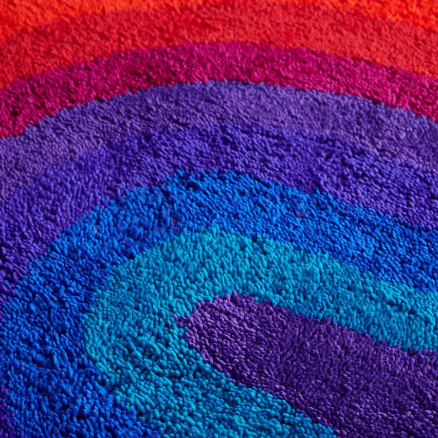 Lavish Amini Romantica-Curve rug displaying swirling color from deep purple to vibrant blues in hand-tufted New Zealand wool with a plush finish