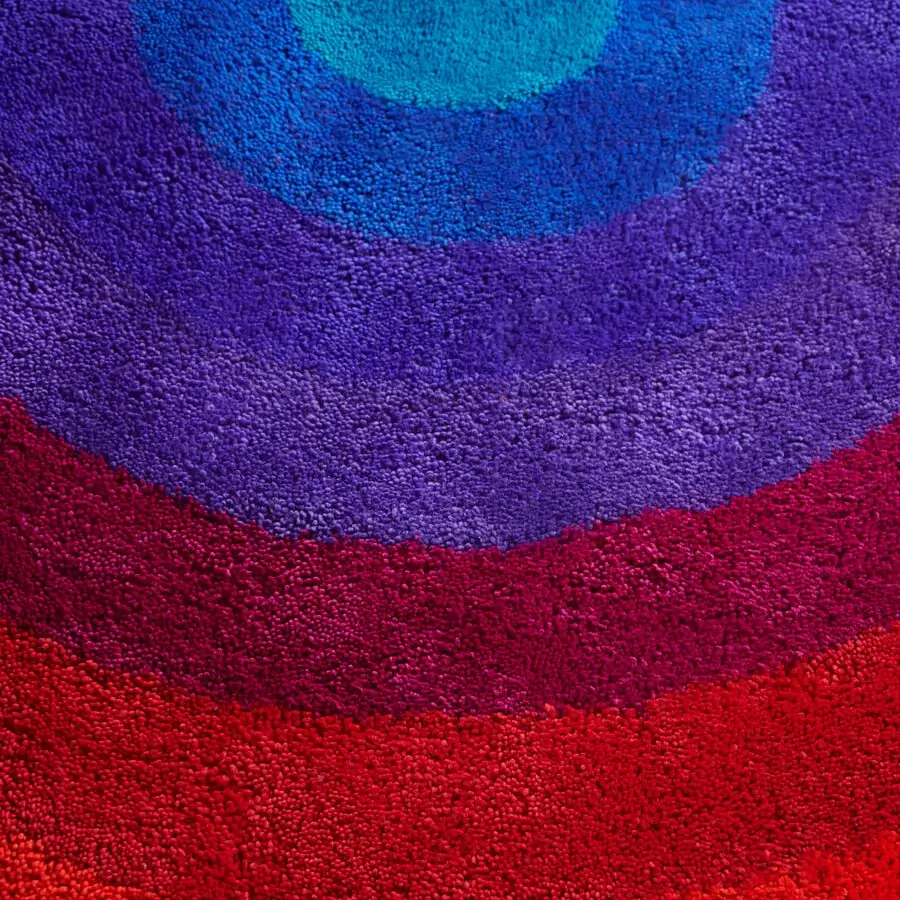 Captivating Amini Romantica-Circle rug hand-tufted in New Zealand wool with a gradient of red, purple, and turquoise, finished with a carved technique