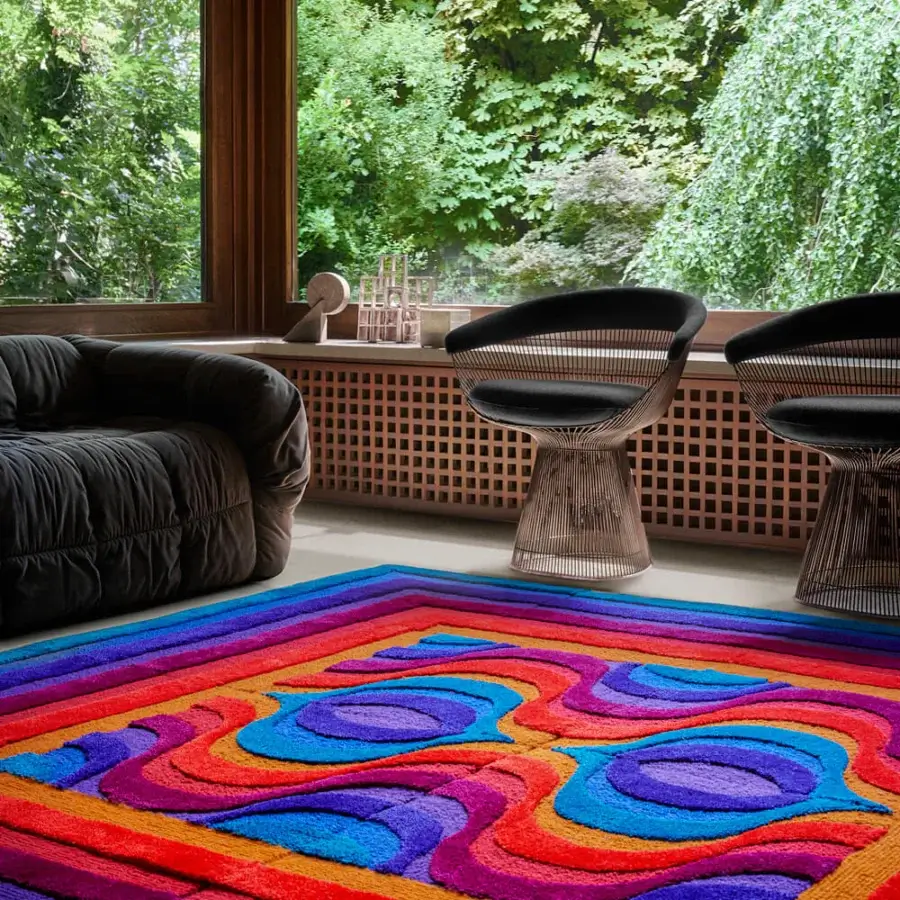 Lavish Amini Domino rug with swirling concentric patterns in red, orange, yellow, blue, and purple New Zealand wool, hand-washed and carved