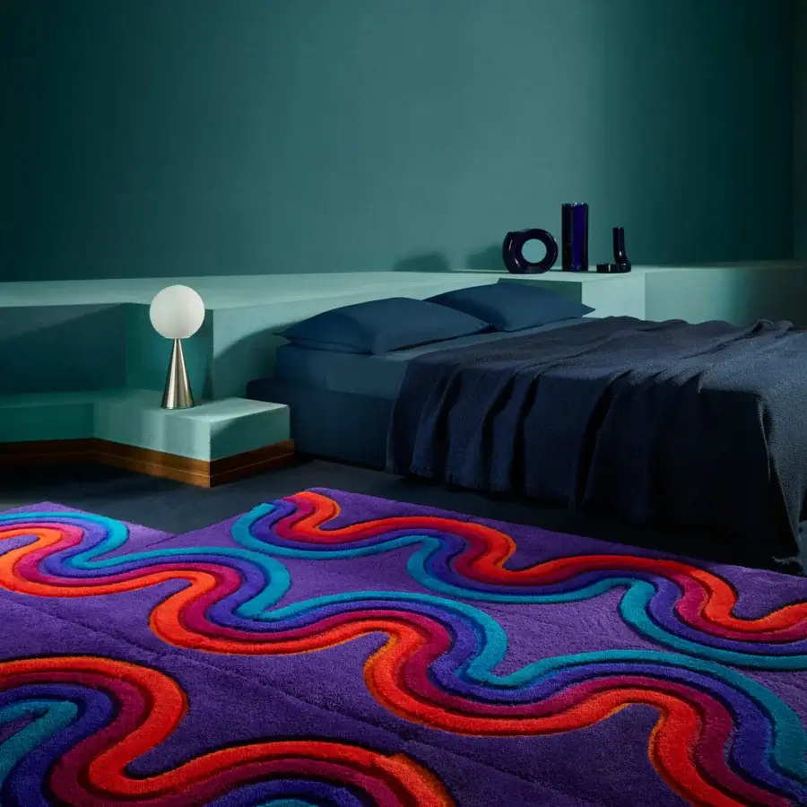 Exceptional Amini Domino rug hand-tufted with curvilinear designs in red, turquoise, and orange against a purple background wool pile