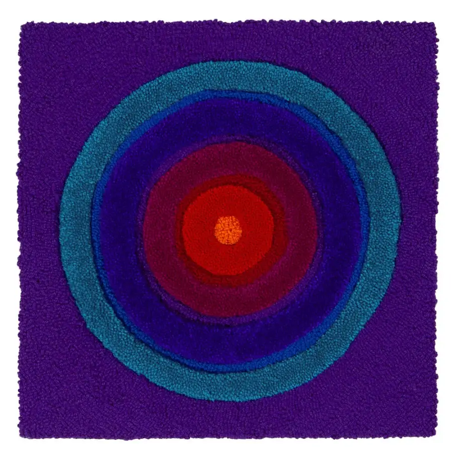 Captivating Amini Domino rug hand-tufted in New Zealand wool with concentric bands of purple, blue, and red hues, exhibiting a carved finish