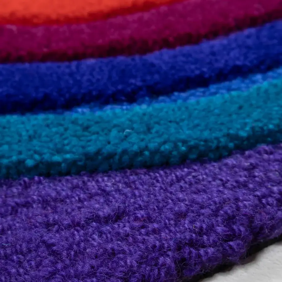 Exceptional Amini Domino rug hand-tufted from New Zealand wool with vibrant purple, blue, and orange-red striped pattern and carved texture