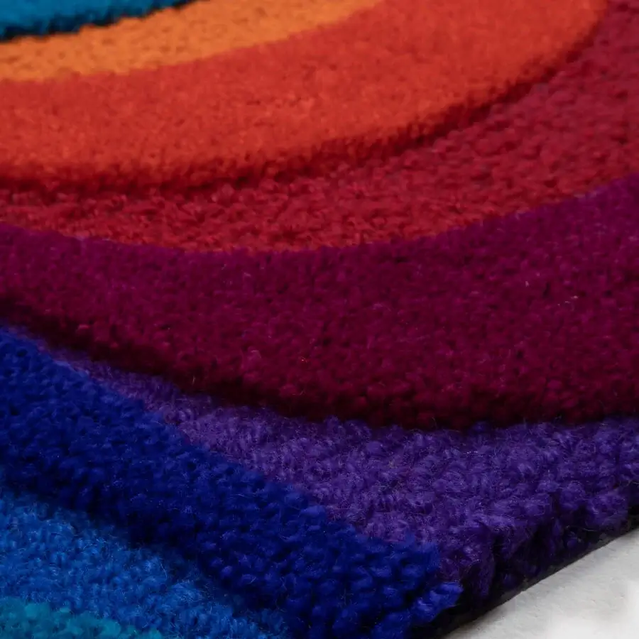 Lavish Amini Domino rug crafted from New Zealand wool with swirling bands in turquoise, orange, red, magenta, and indigo hues
