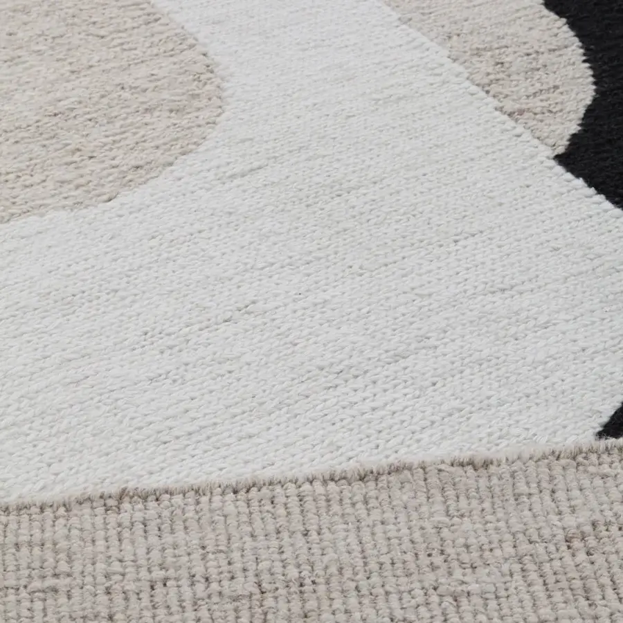 Lavish Amini Jean rug with a captivating arrangement of black and ivory shapes hand-clipped in 100% wool pile crafted in Italy