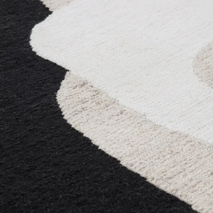 Exceptional Amini Jean rug hand-clipped with a soft wool pile, showcasing chromatic contrast in dark grey and ivory hues