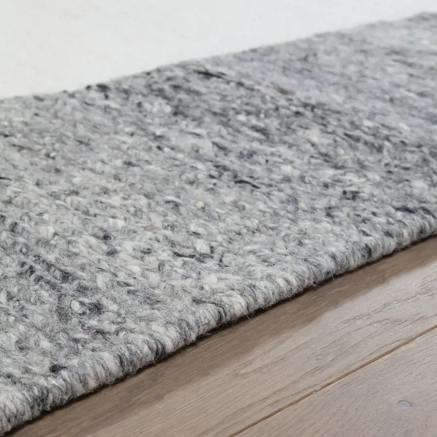 Superior Amini Jean rug woven with soft wool in heathered medium gray tones and irregular edges, finished with hand clipping