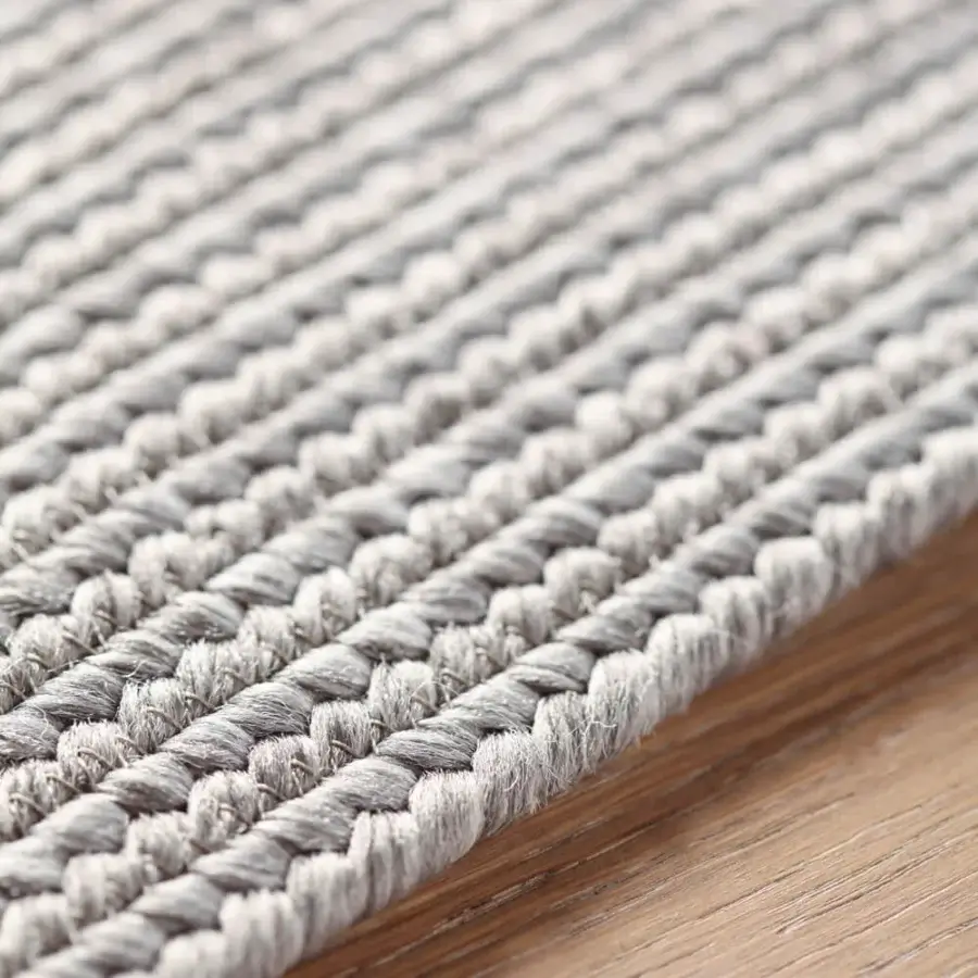 Distinguished Amini Plain rug hand-braided with polypropylene, viscose, and polyester in a heathered light grey tone