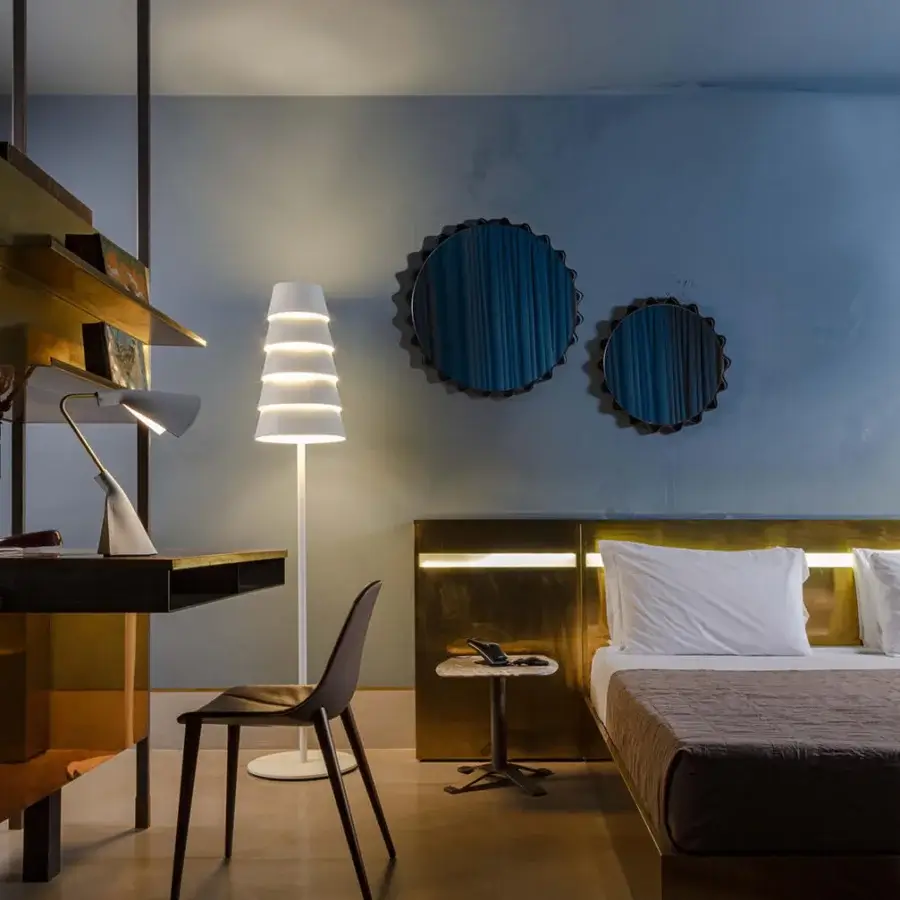Lavish Enrico Pellizzoni Glimt mirror with a round, wavy frame built in dark-toned wood and supple leather with brass studs