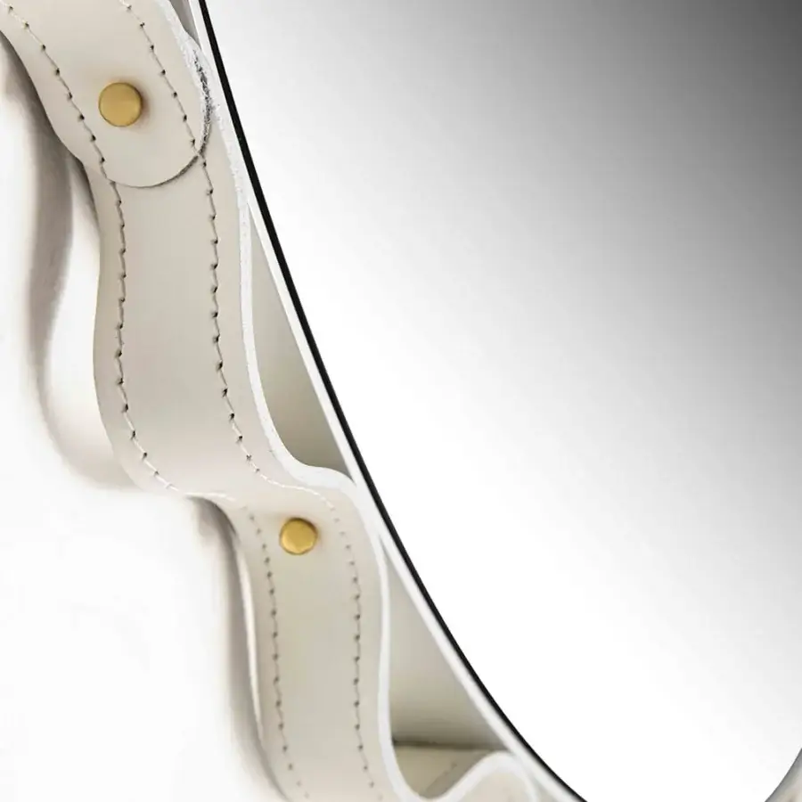 Lavish Enrico Pellizzoni Glimt mirror with a round, wavy frame built in supple leather and secured with bright brass studs in a satin finish