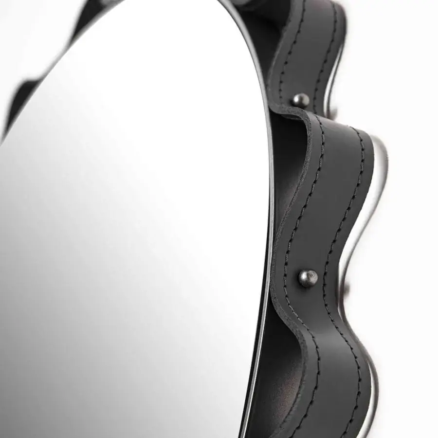 Superior Enrico Pellizzoni Glimt mirror with a round, wavy frame built in smooth leather and secured with bright brass studs