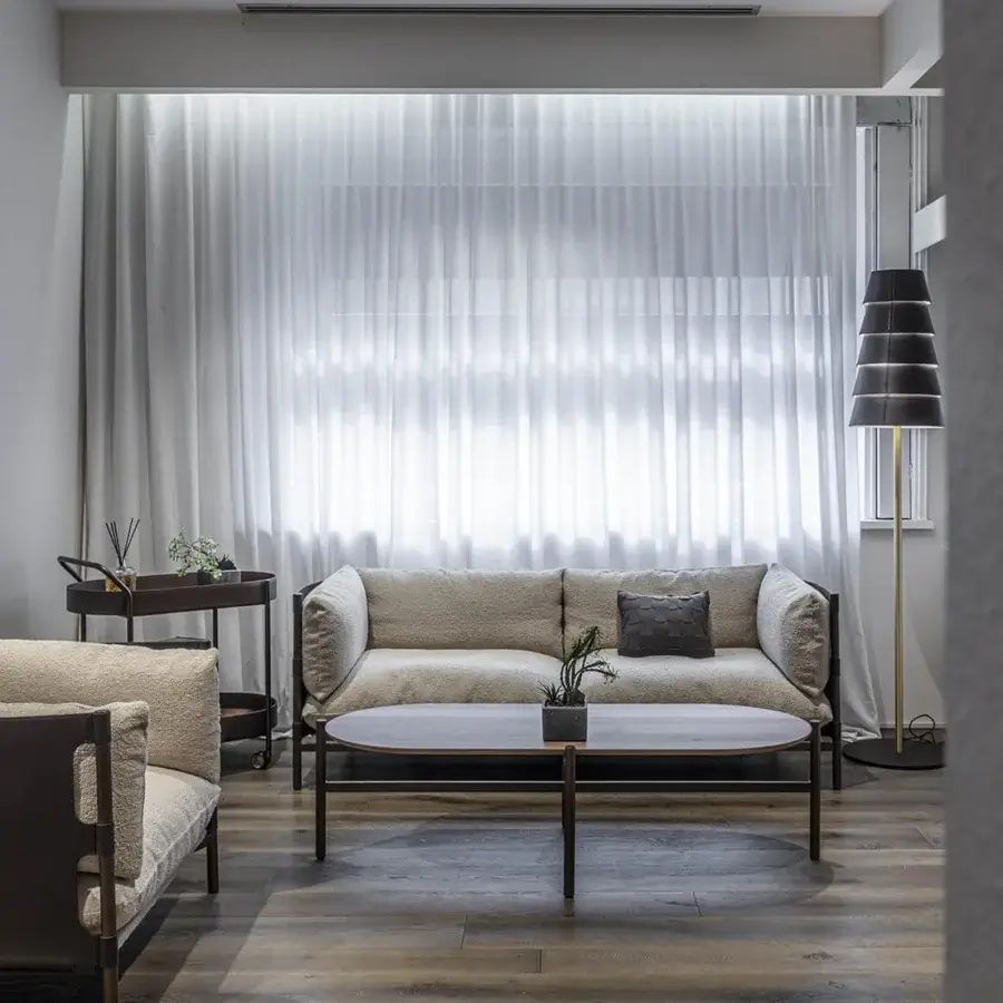 Superior Enrico Pellizzoni Iris sofa with light beige textile upholstery, dark wood base and leather detailing in a matte finish