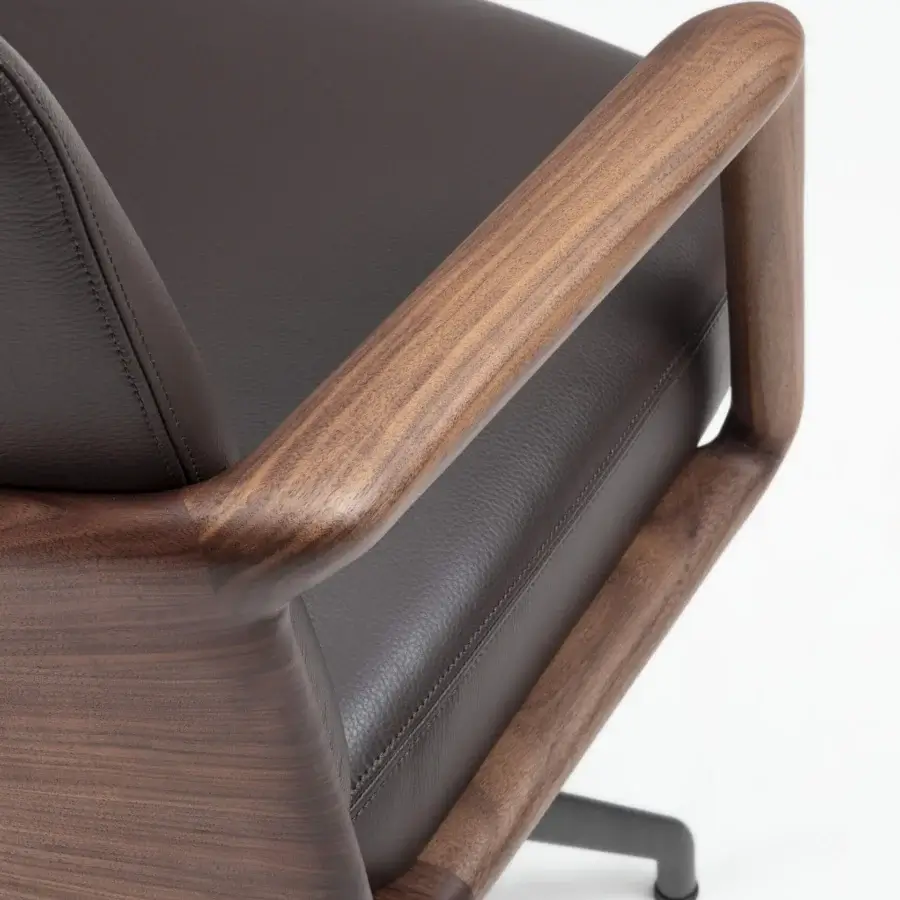Exceptional Porada Cuna swivel chair crafted in Italy with sculpted Canaletta walnut and dark brown leather upholstery with a satin finish