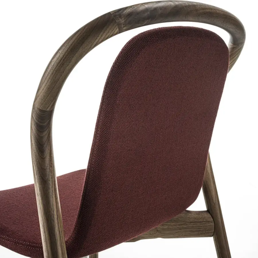 Lavish Porada Petra chair with solid Canaletta walnut frame and gently contoured burgundy upholstery