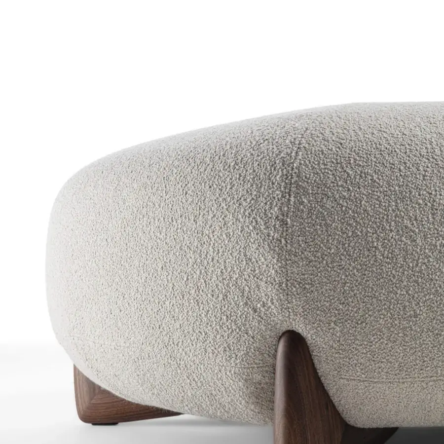 Lavish Porada Softbay ottoman in off-white bouclé upholstery with dark-toned wood paperclip legs and birch plywood build