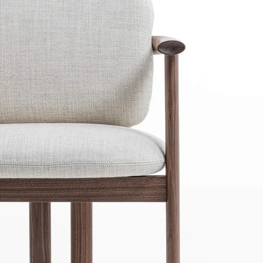 Distinguished Porada Teti chair crafted in solid wood with satin finish and light beige textured cushions