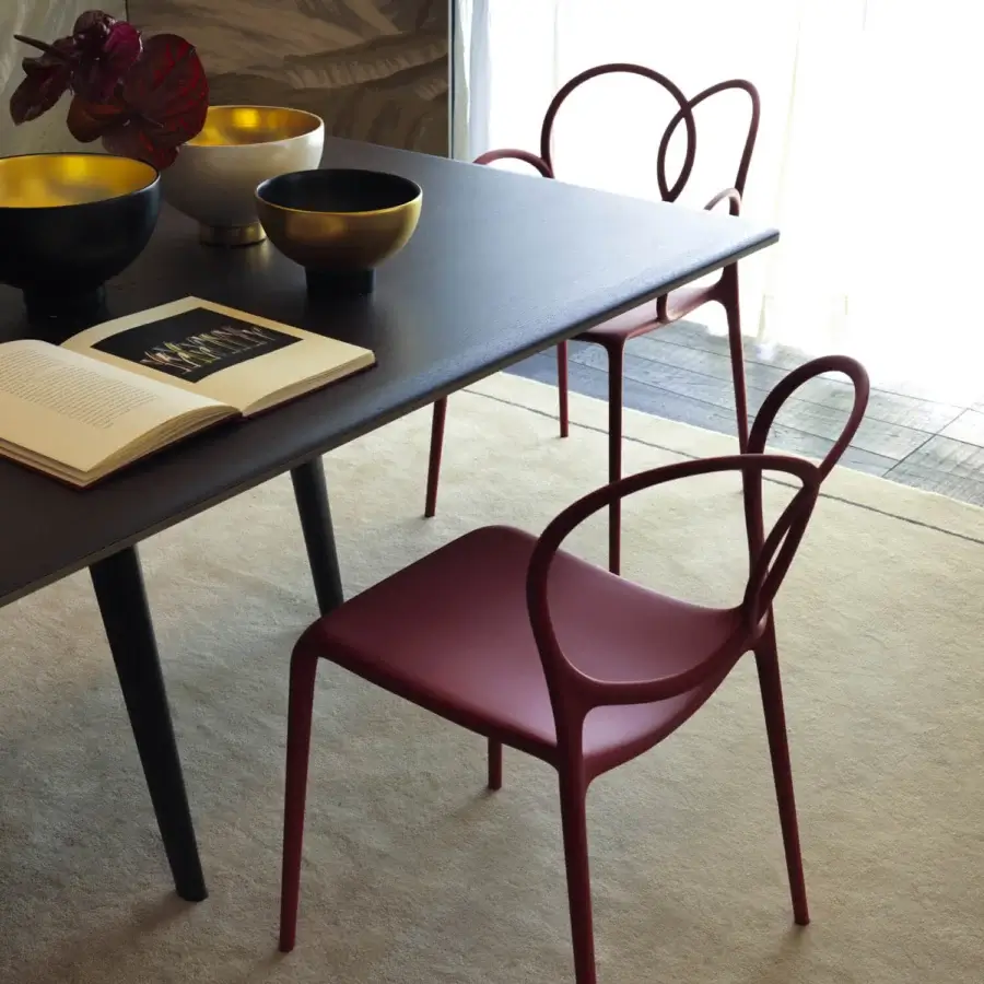 Captivating Driade Sissi chair molded from glass fiber reinforced copolymer in reddish-burgundy with a smooth matte finish