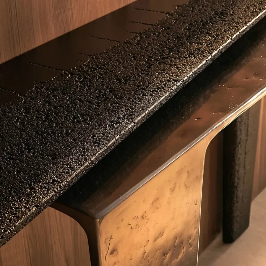 Distinguished Visionnaire Lego console crafted with eroded matte black concrete and brassy gold-toned metal exhibiting a sand-cast texture