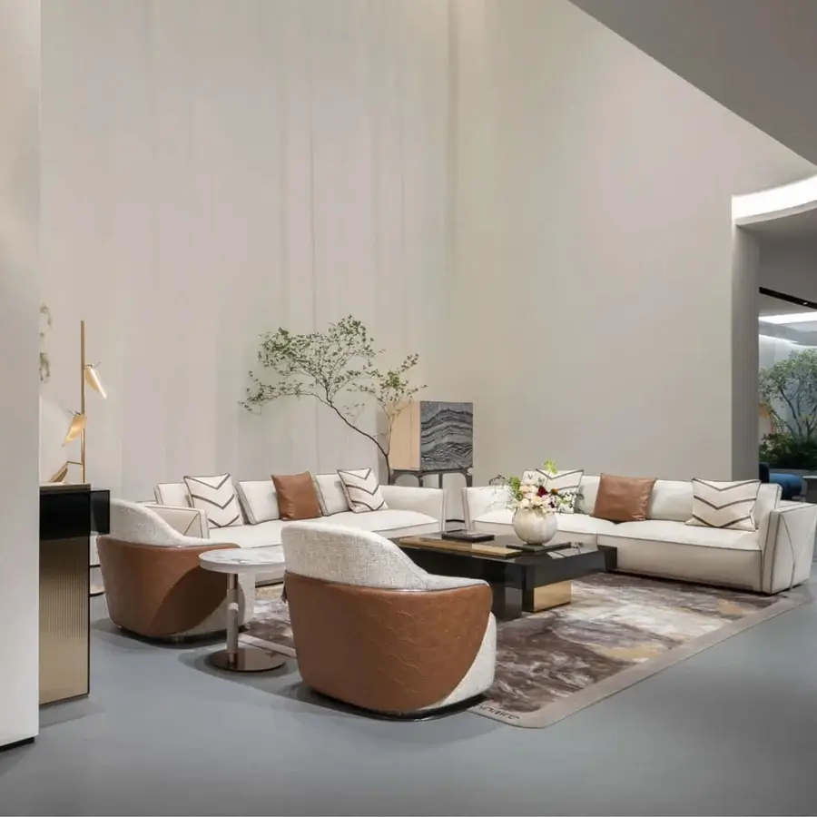 Lavish Visionnaire Bastian sofa with neutral beige textile upholstery, contrasting brown and gold cushions, satinized stainless steel accents, and black lacquered feet