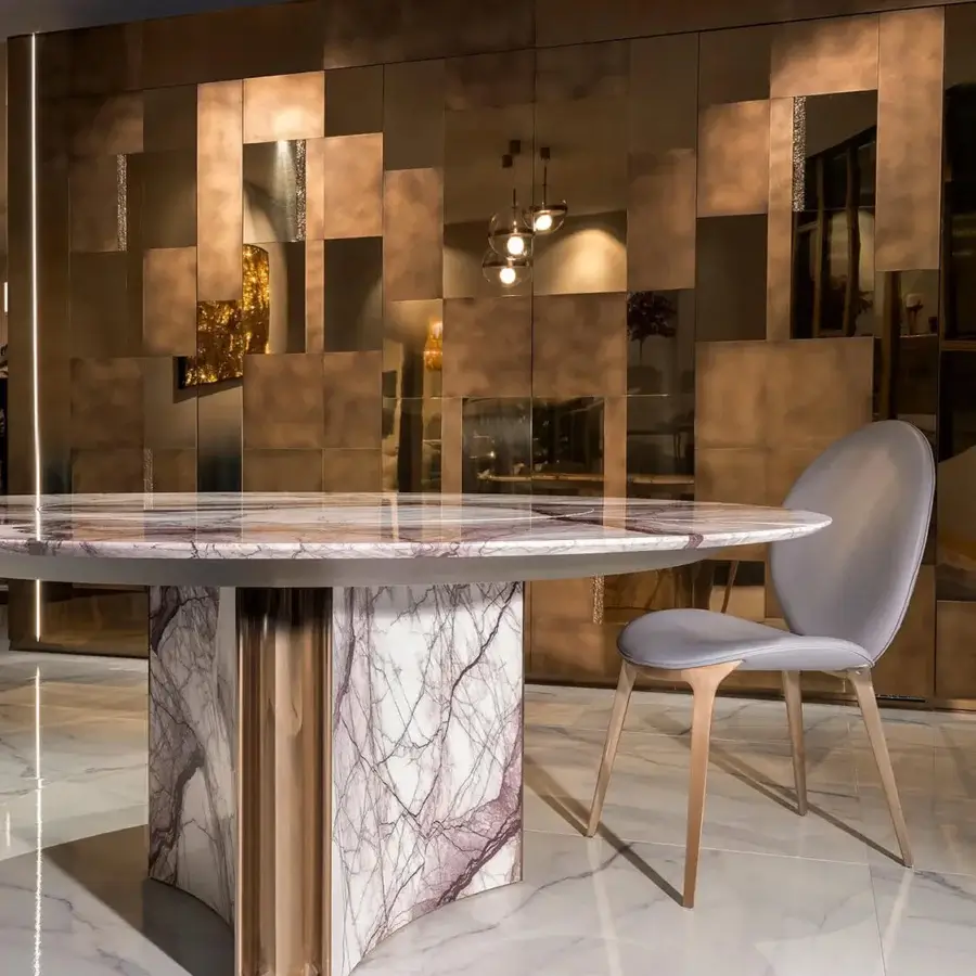 Superior Visionnaire Kerwan table with white marble, mauve veining and glossy polished stone paired with satin golden stainless steel volumes