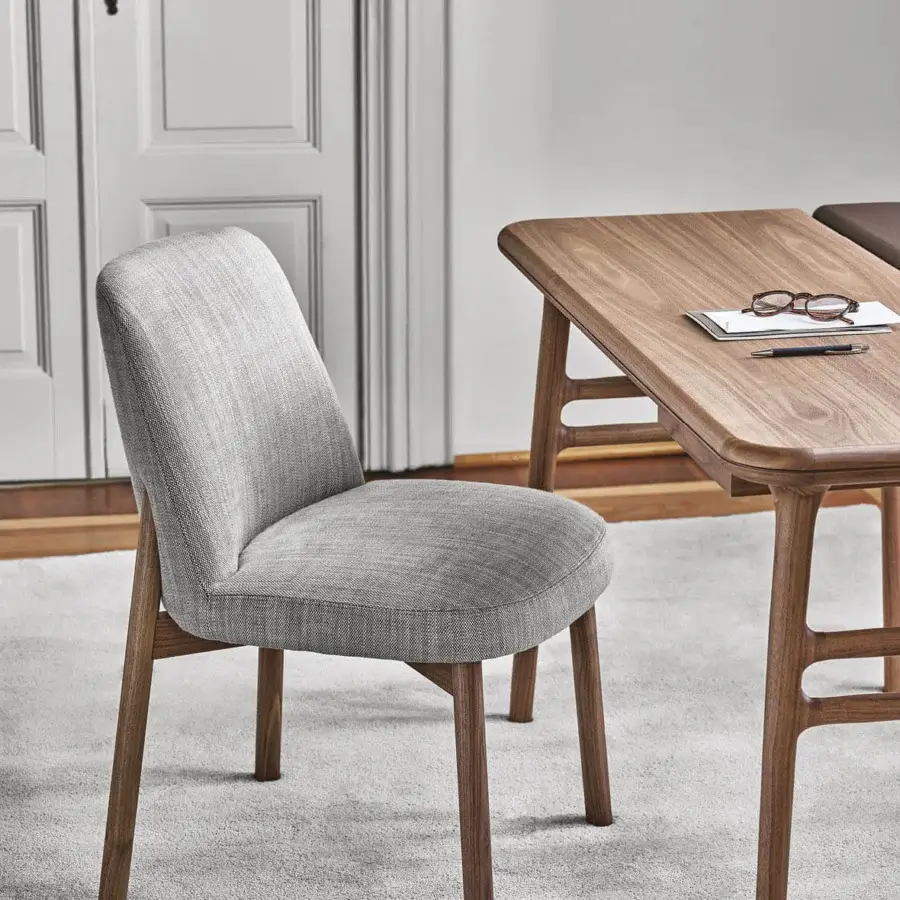 Elegant Porada Abby chair crafted with a gently curved Canaletto walnut frame and muted gray textile upholstery