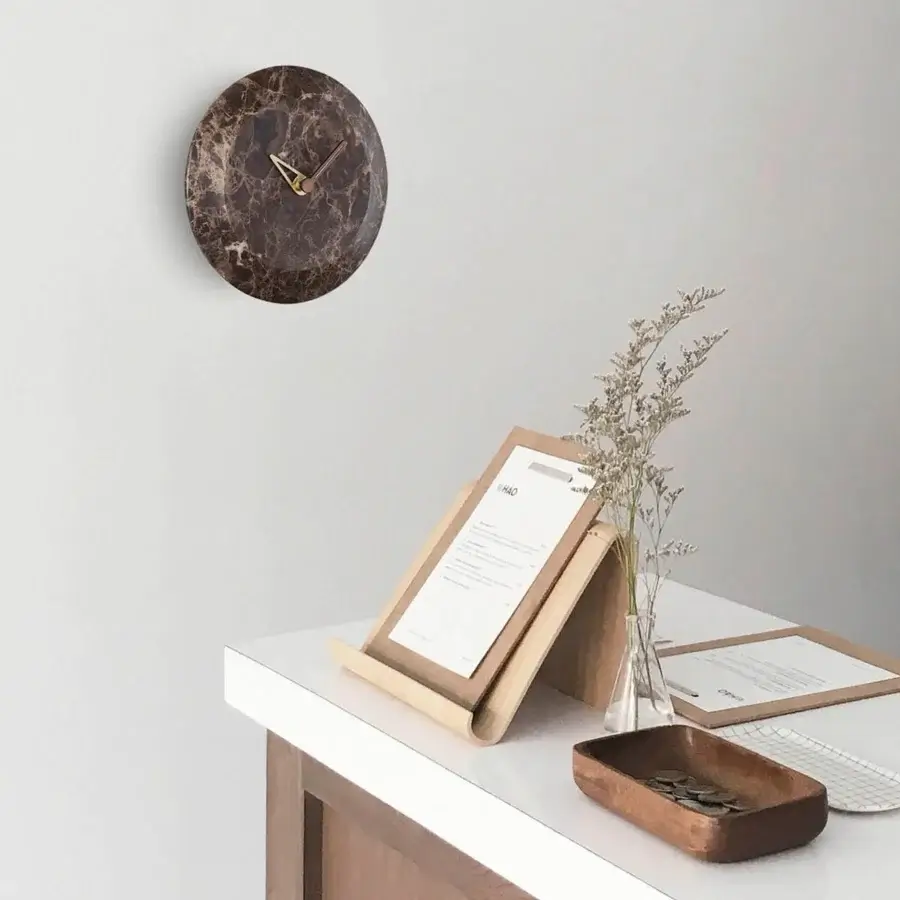 Superior Nomon Bari wall clock with a polished marble face, warm walnut accents and sophisticated brass hands