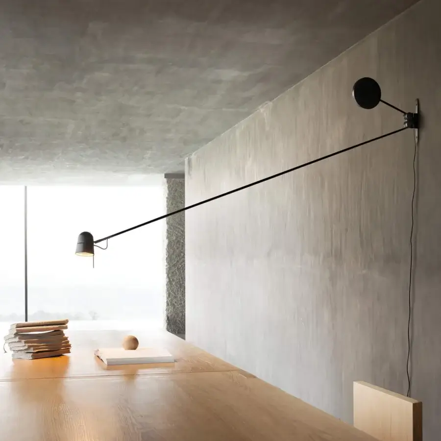 Distinguished Luceplan Counterbalance wall lamp crafted in matte black painted steel with a polished aluminum head and extended adjustable arm