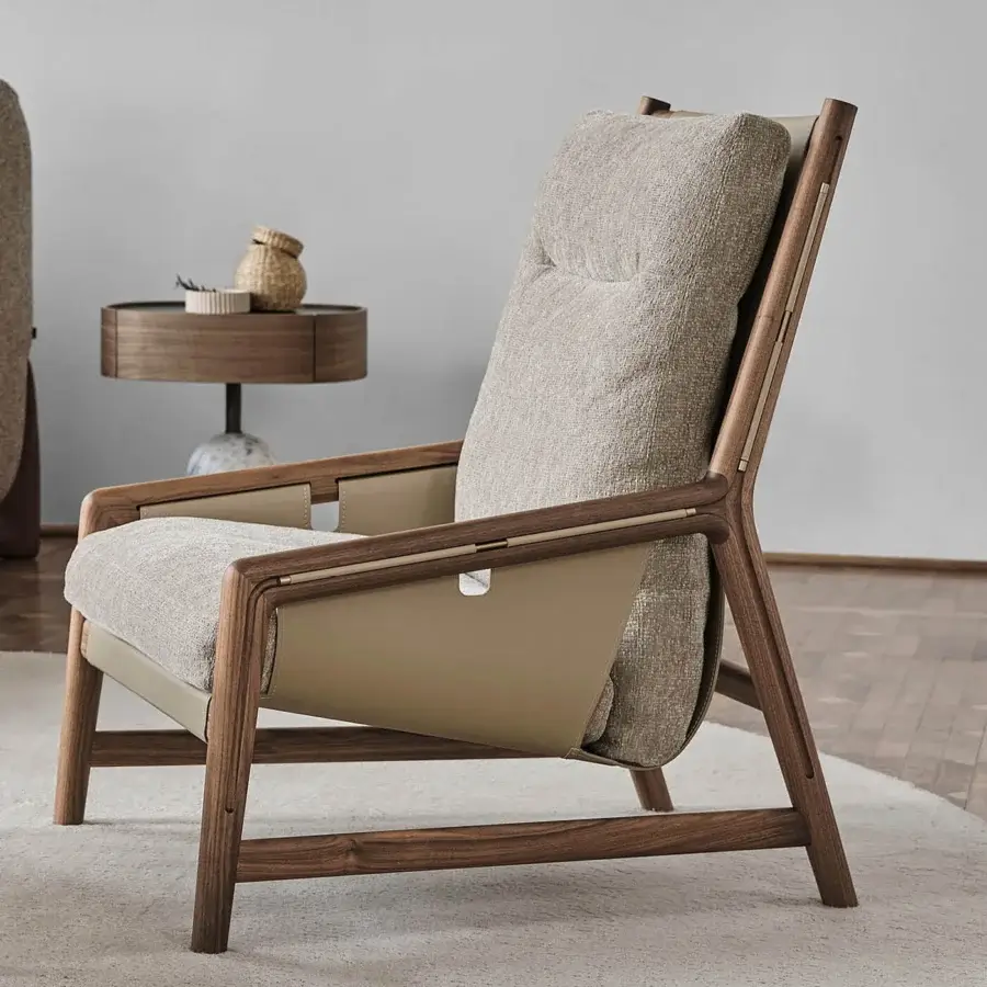 Distinguished Porada Bice armchair with solid Canaletto walnut frame, textured neutral gray textile and Champagne metal detailing