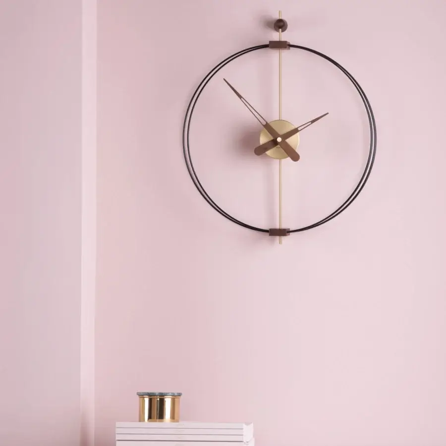 Elegant Nomon Micro Barcelona wall clock with a black fiberglass double ring framing walnut and fine metal details in satin brass