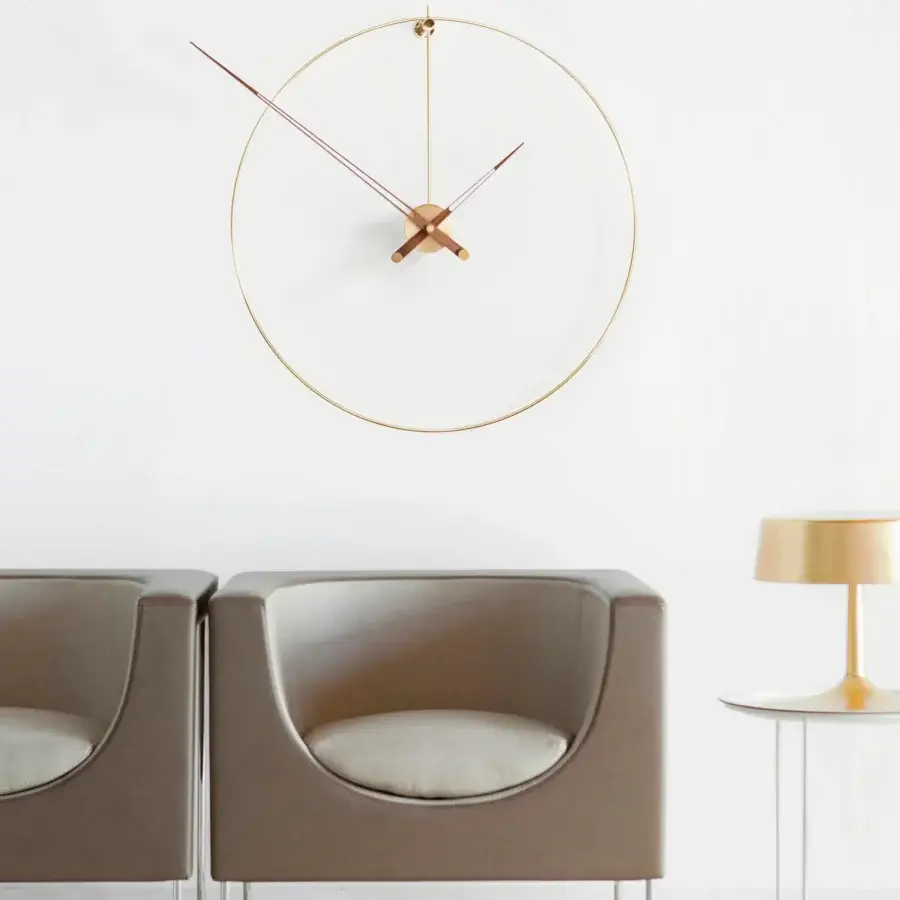 Distinguished Nomon New Anda wall clock with suspended metal ring and light beige face framed in gold-toned metal