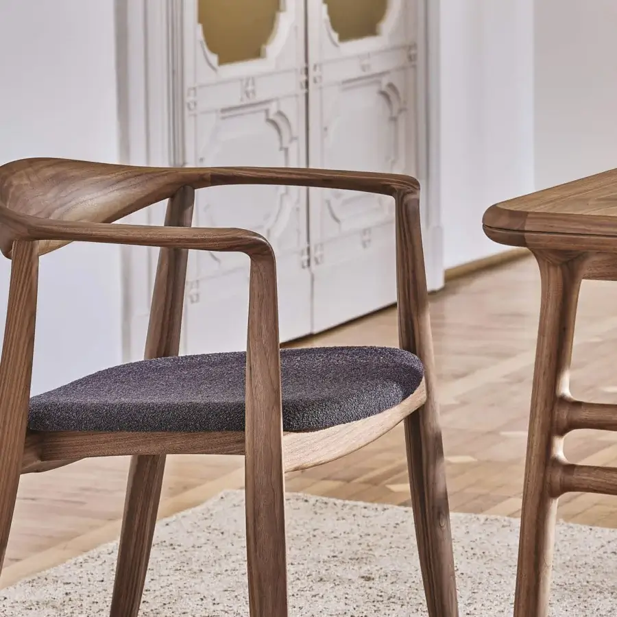 Elegant Porada Frida armchair with sculpted solid canaletto walnut frame and dark gray textured upholstery