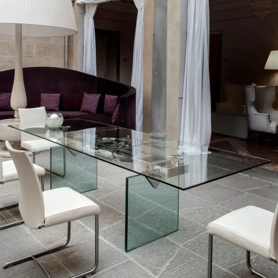 Superior Naos Quasar table crafted with clear glass, subtly greenish edges, and stratified glass legs in a glossy finish