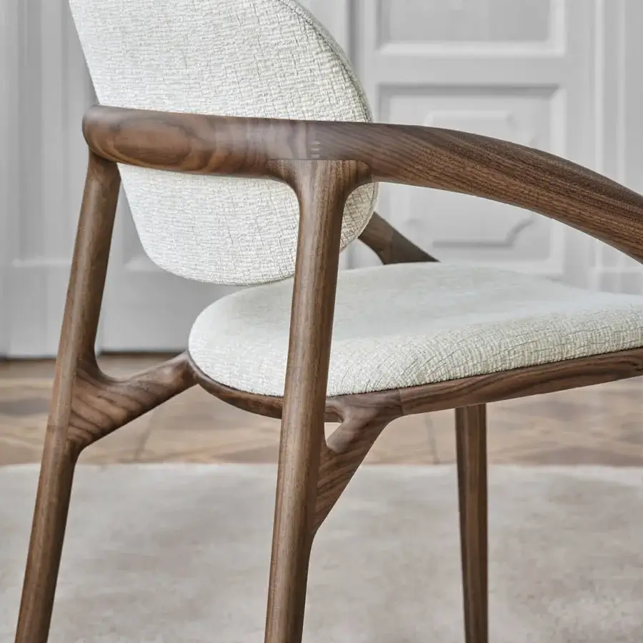 Distinguished Porada Molly armchair with a continuous canaletto walnut frame and neutral beige textile upholstery
